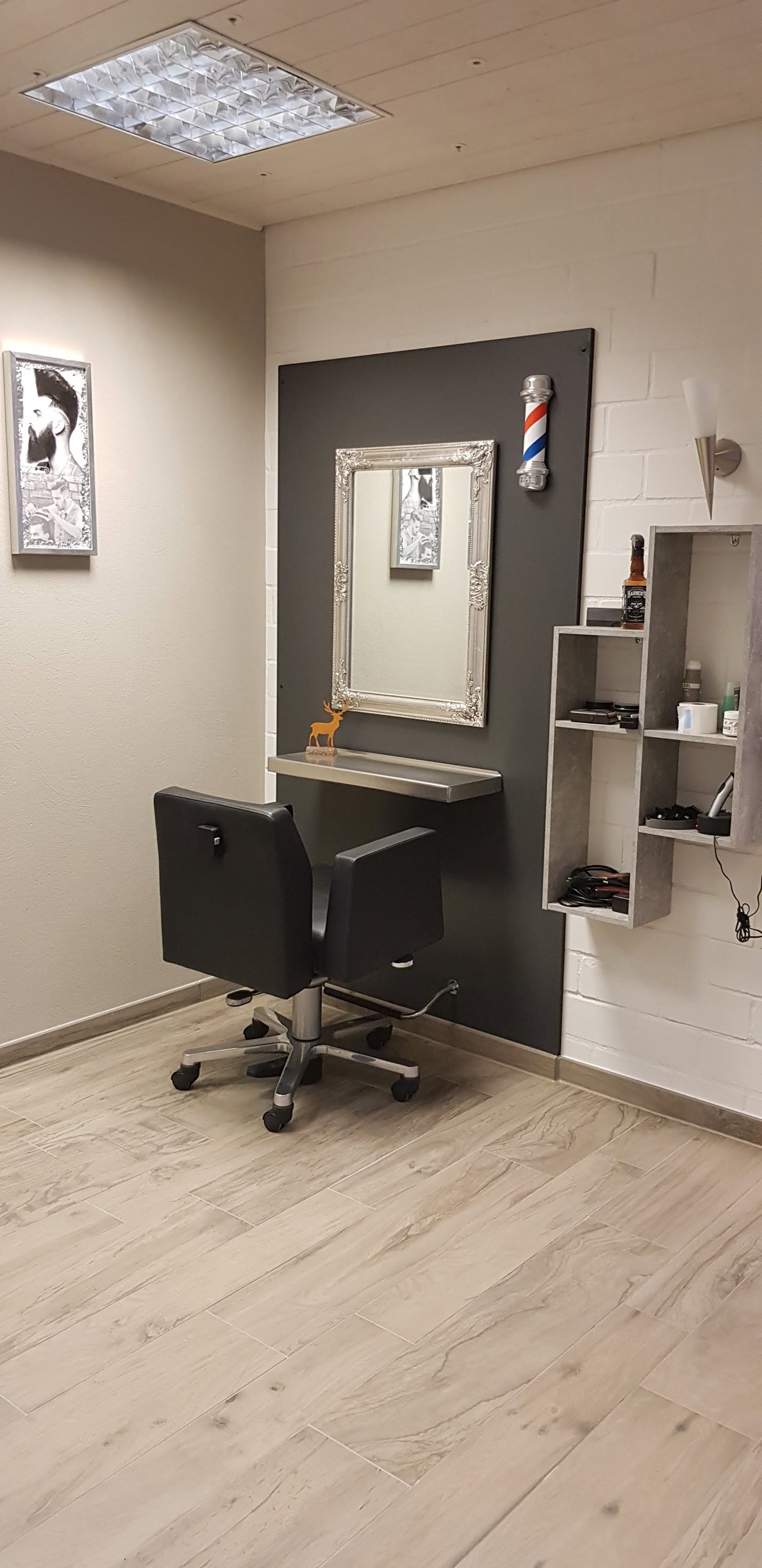 Friseurplatz mit Spiegel und Barbier-Deko im Salon Hair-Fashion Angela